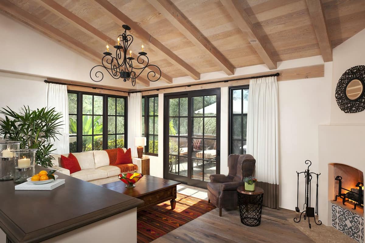 A spacious living room with a fireplace, large windows, and a cozy seating area.