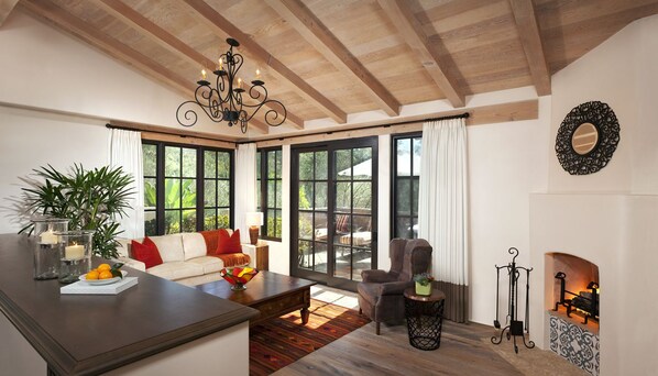 A spacious living room with a fireplace, large windows, and a cozy seating area.
