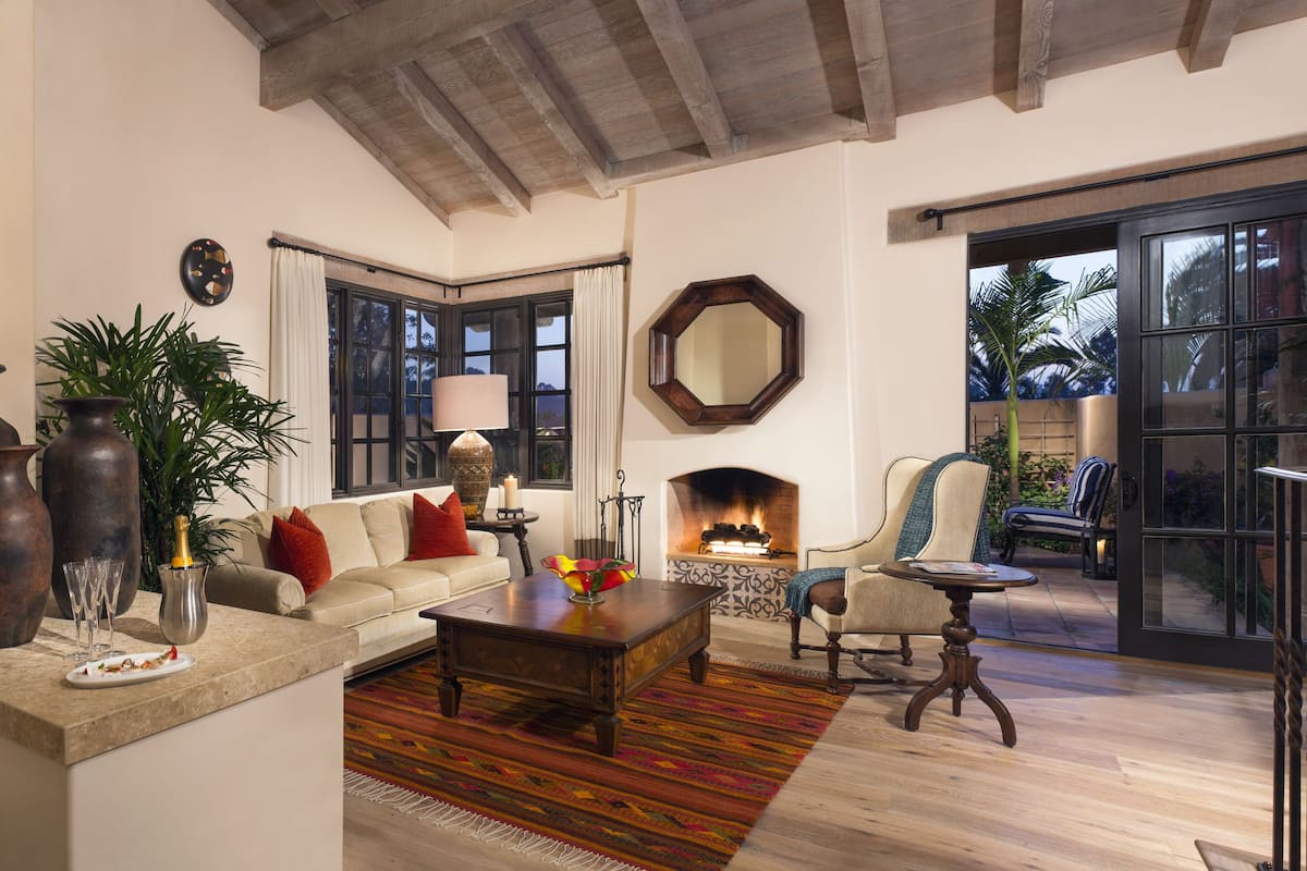 A cozy living room with a fireplace, a sofa, a coffee table, and a chair.