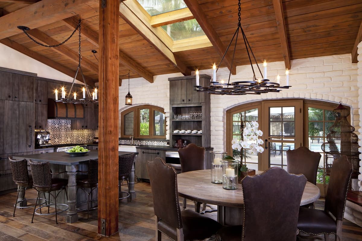 A spacious kitchen with a large island, wooden beams, and a skylight.