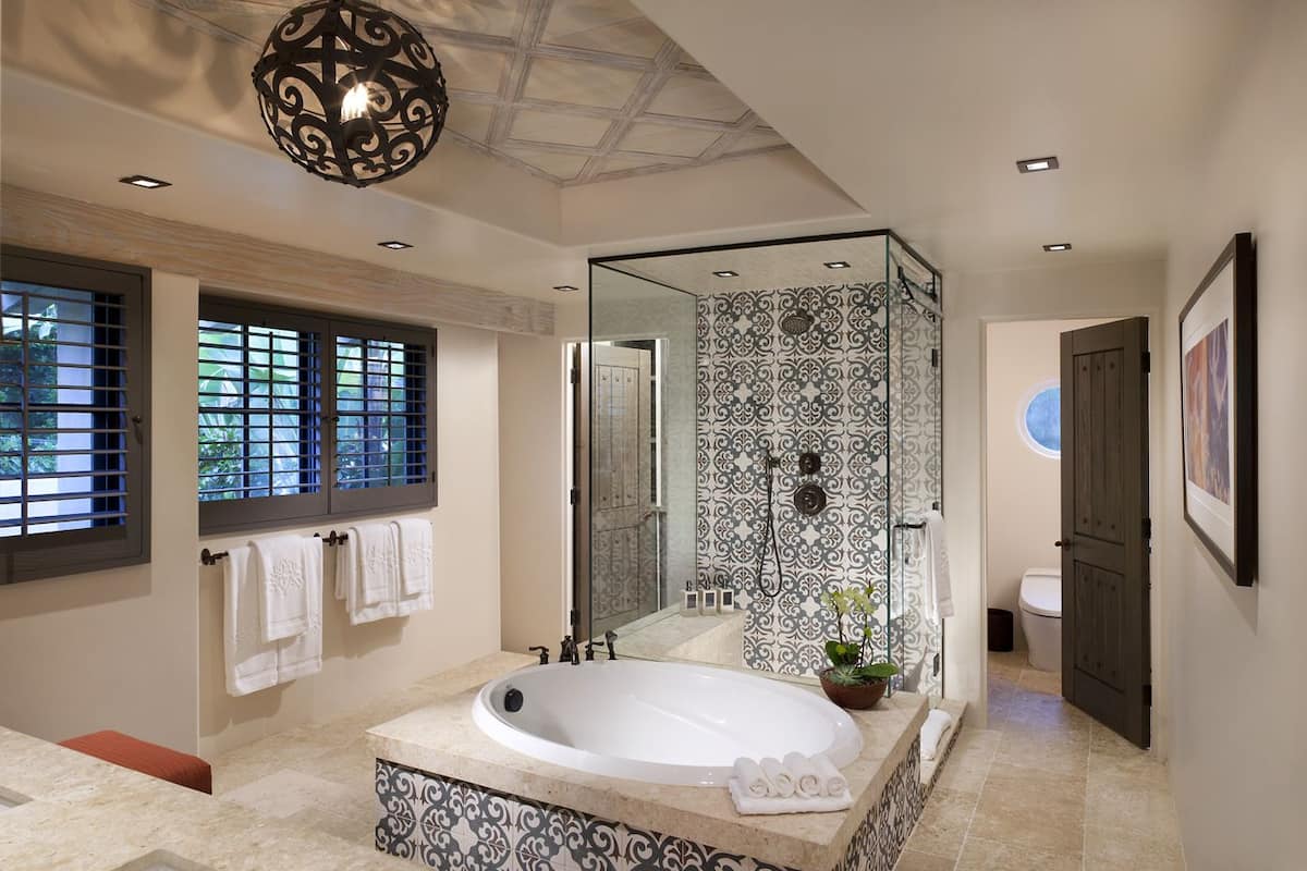 A modern bathroom with a freestanding bathtub, a glass-enclosed shower, and a large mirror.