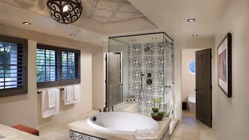 Un baño moderno con una bañera independiente, una ducha con cerramiento de vidrio y un espejo grande.