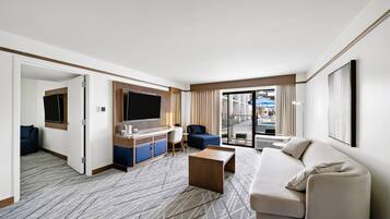 Suite, 1 très grand lit, patio, au bord de la piscine | Aire de séjour | Téléviseur, films payants