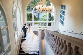 A hotel room with two beds, a large artwork on the wall, a television on a wooden cabinet, and a view of the sea through the door. at The Ritz-Carlton, Laguna Niguel