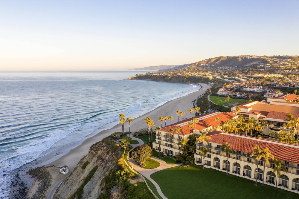 Aerial view of a luxurious beach resort in Southern California, with turquoise waters and white sand stretching into the distance