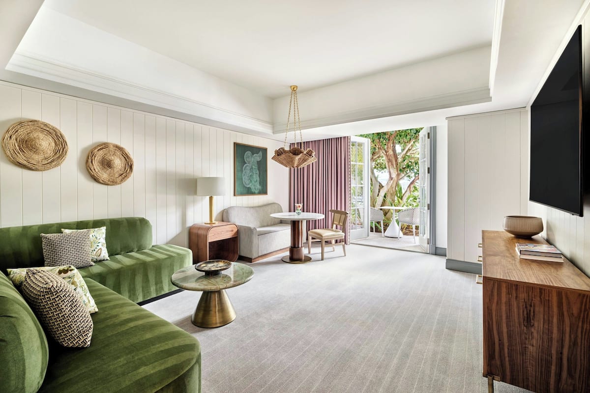 A modern living room with a green sofa, a round coffee table, and a wooden side table.