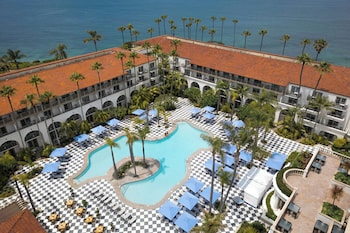 A coastal view from a balcony with a curved balustrade overlooking a sandy beach and ocean. at The Ritz-Carlton, Laguna Niguel