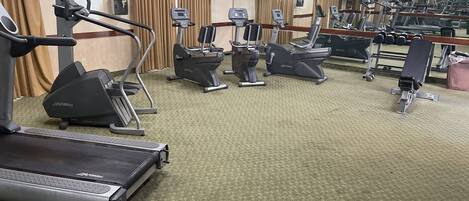A gym with treadmills, elliptical machines, and weight machines.