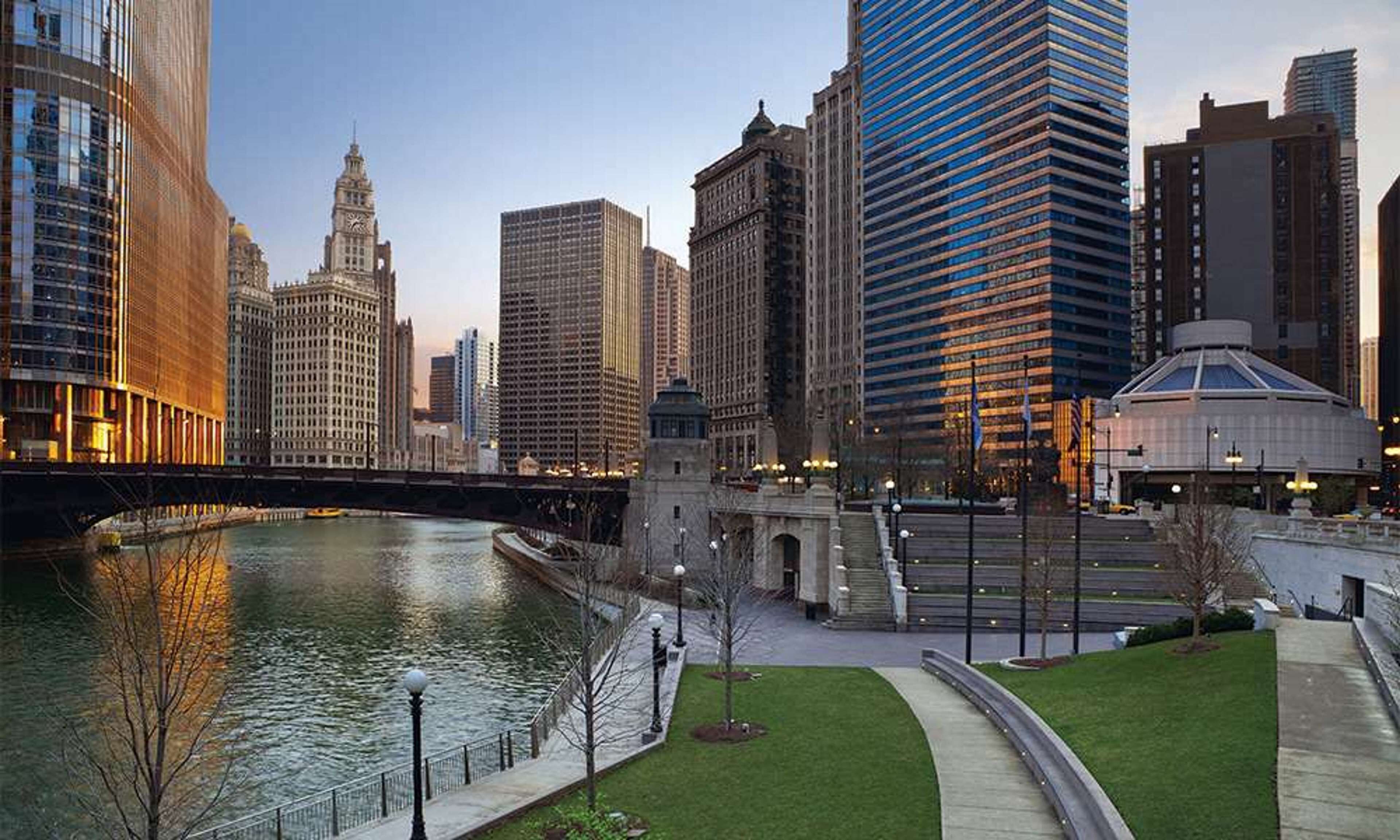 A cityscape with modern buildings, a river, and a bridge.