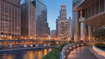 A cityscape with modern high-rise buildings, a river, and a curved walkway with benches.