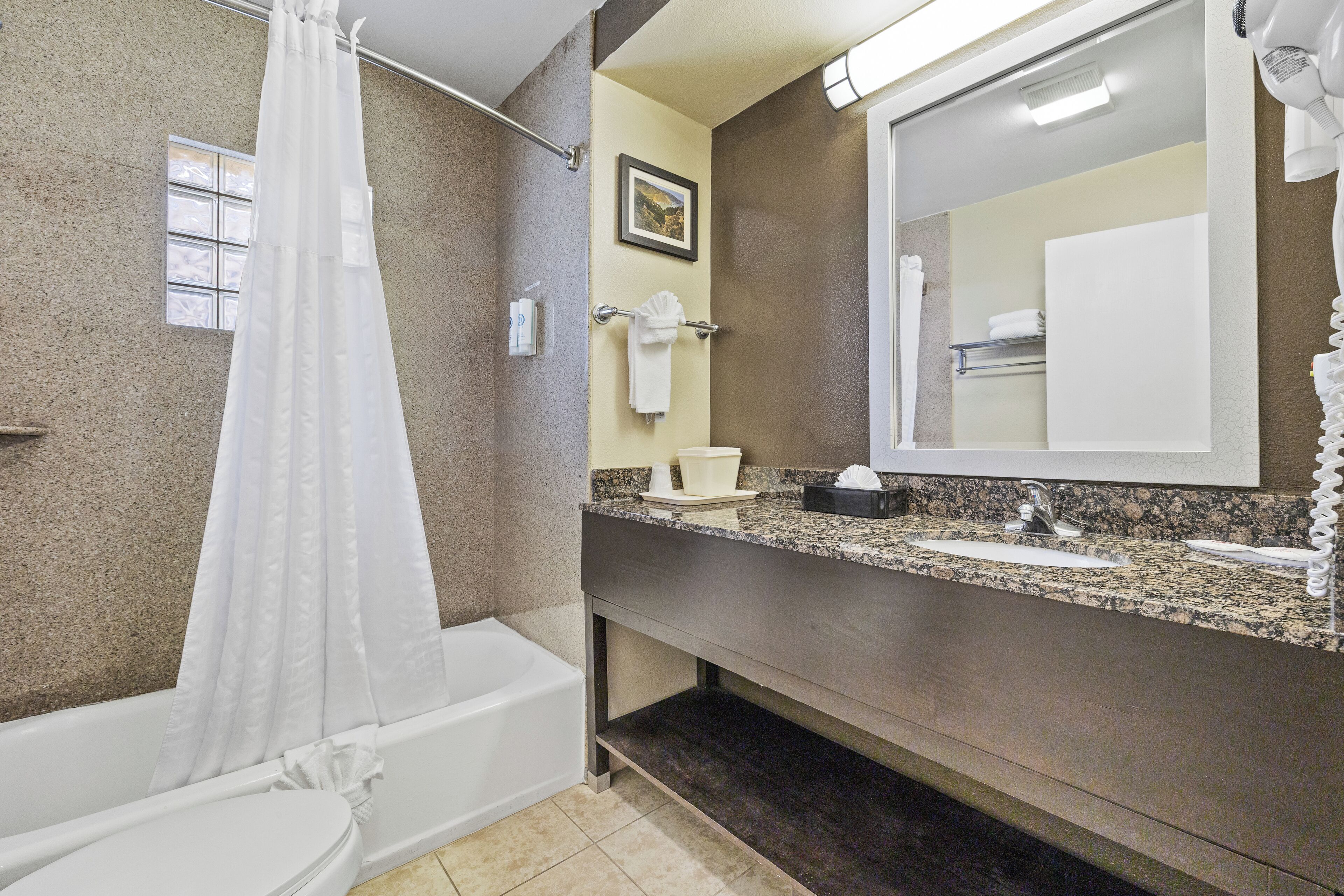 A bathroom with a bathtub, a shower curtain, a sink, a mirror, and a towel rack.