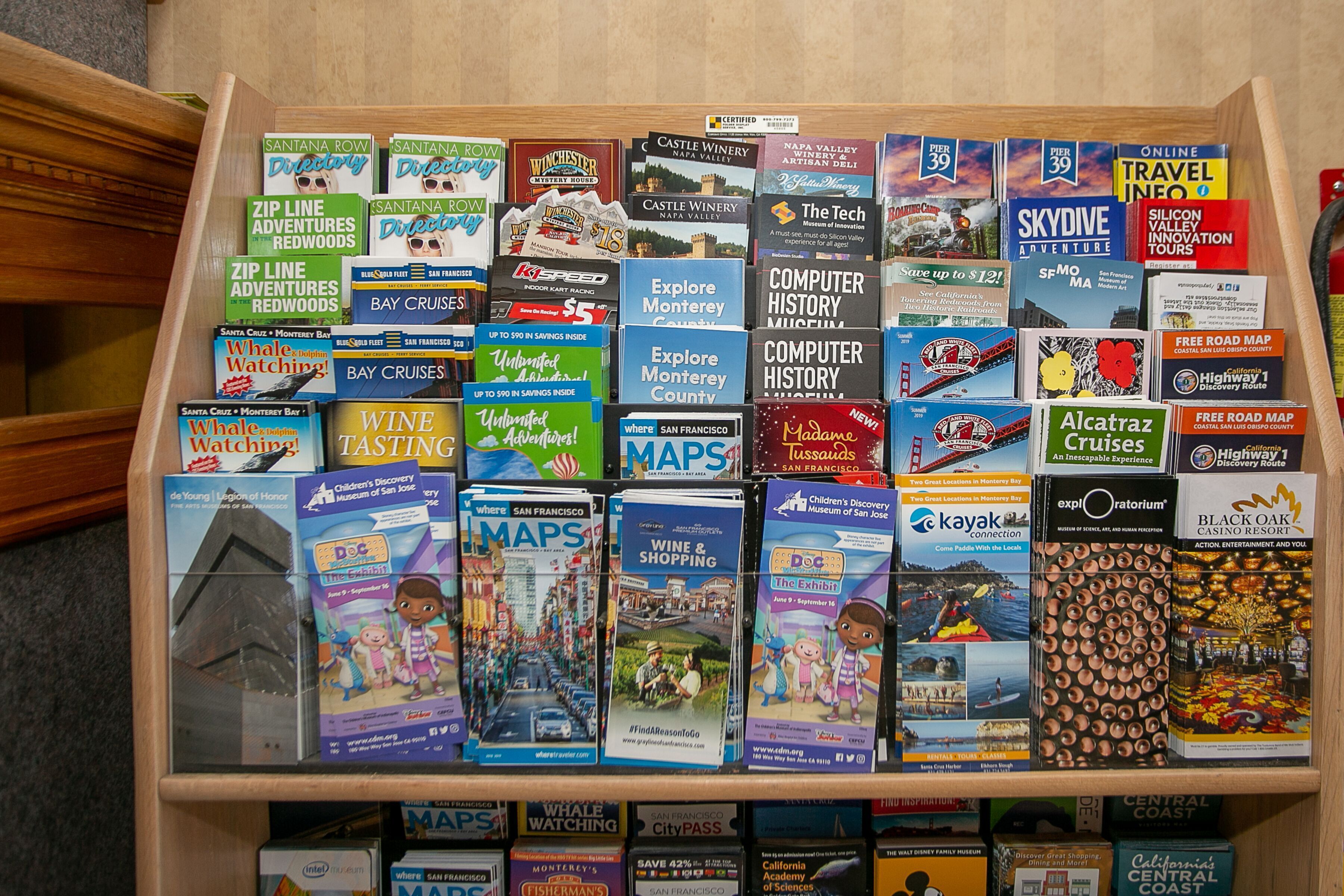 A wooden display case filled with various travel guides and maps.