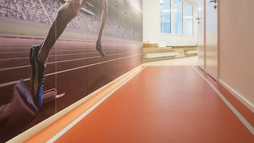 A hallway with a running track, a large mural of a runner, and a number '2' on the floor.