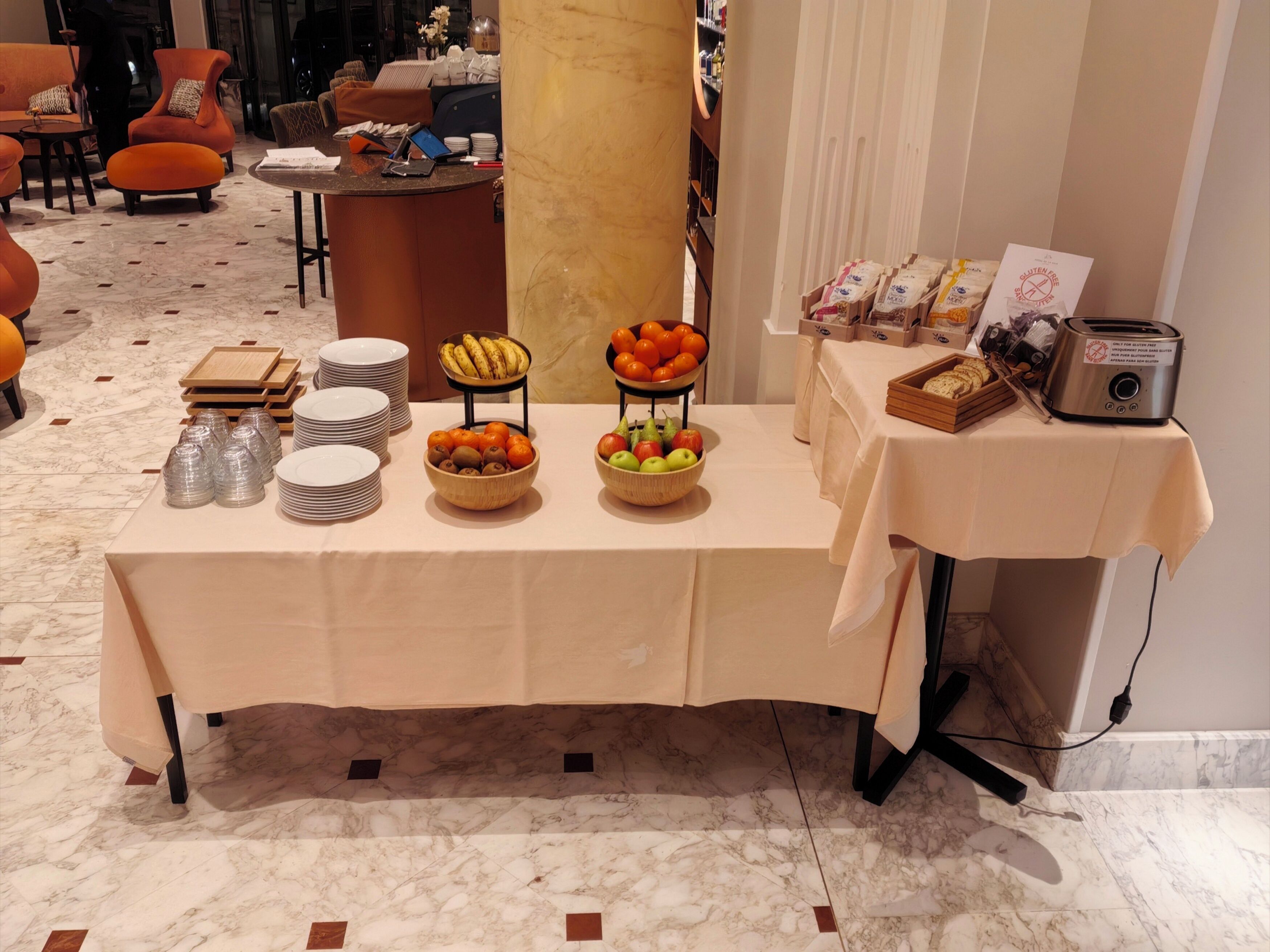A buffet table with various food items, plates, and a toaster.