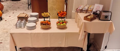 A buffet table with various food items, plates, and a toaster.