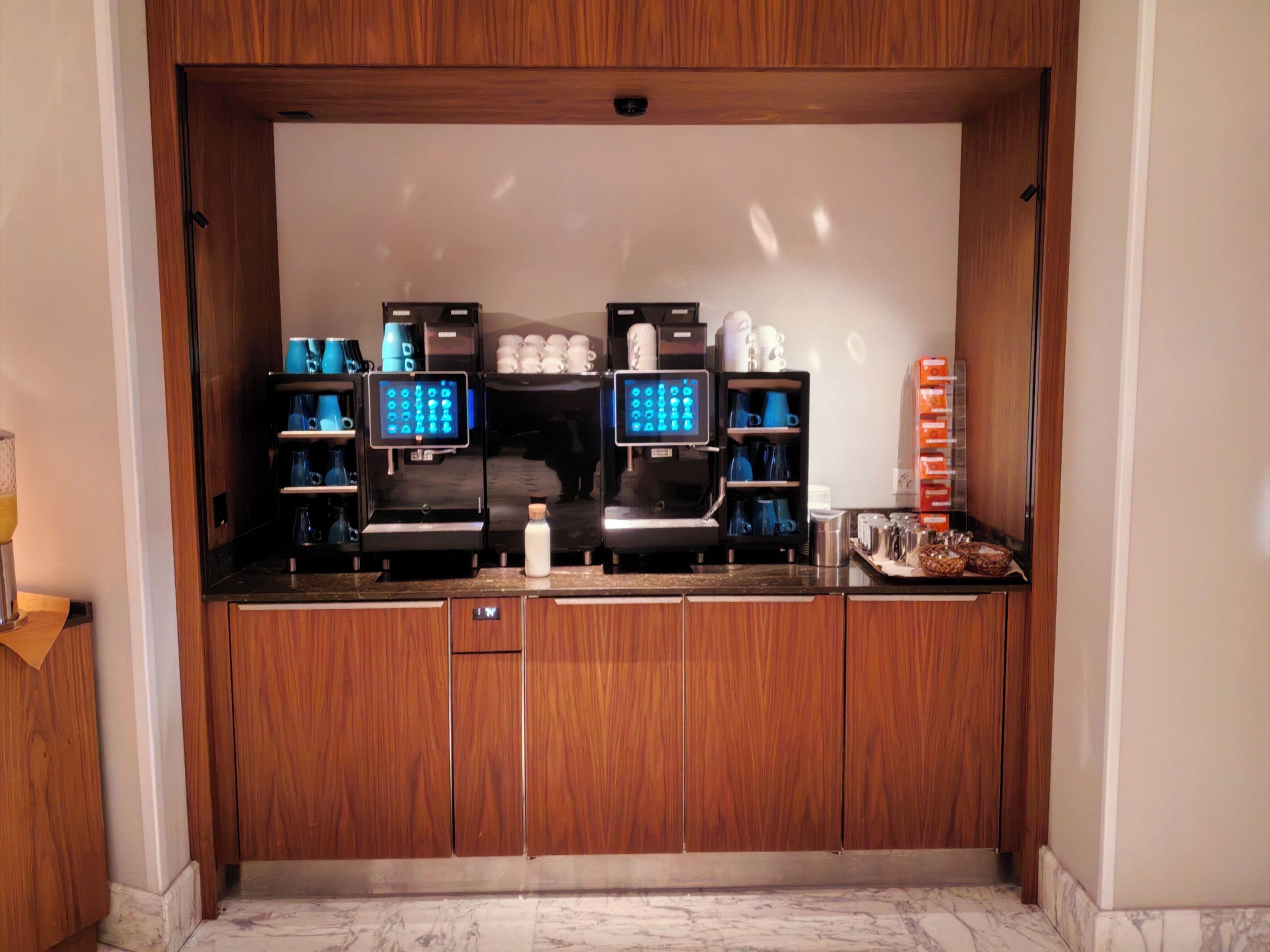 Angolo caffè con diverse macchine per espresso, un dispenser d'acqua e una macchina per il caffè.