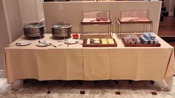 Una mesa de buffet con diferentes alimentos y utensilios.