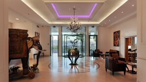 A spacious lobby with a modern chandelier, a large elephant sculpture, and comfortable seating areas. - De la Paix (Lausanne)