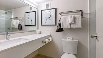 Un baño moderno con un lavabo blanco, un inodoro y un box de ducha de vidrio.