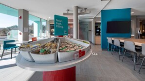 A breakfast buffet area with labeled containers of cereals and a sign indicating fresh, fast, and filling options.