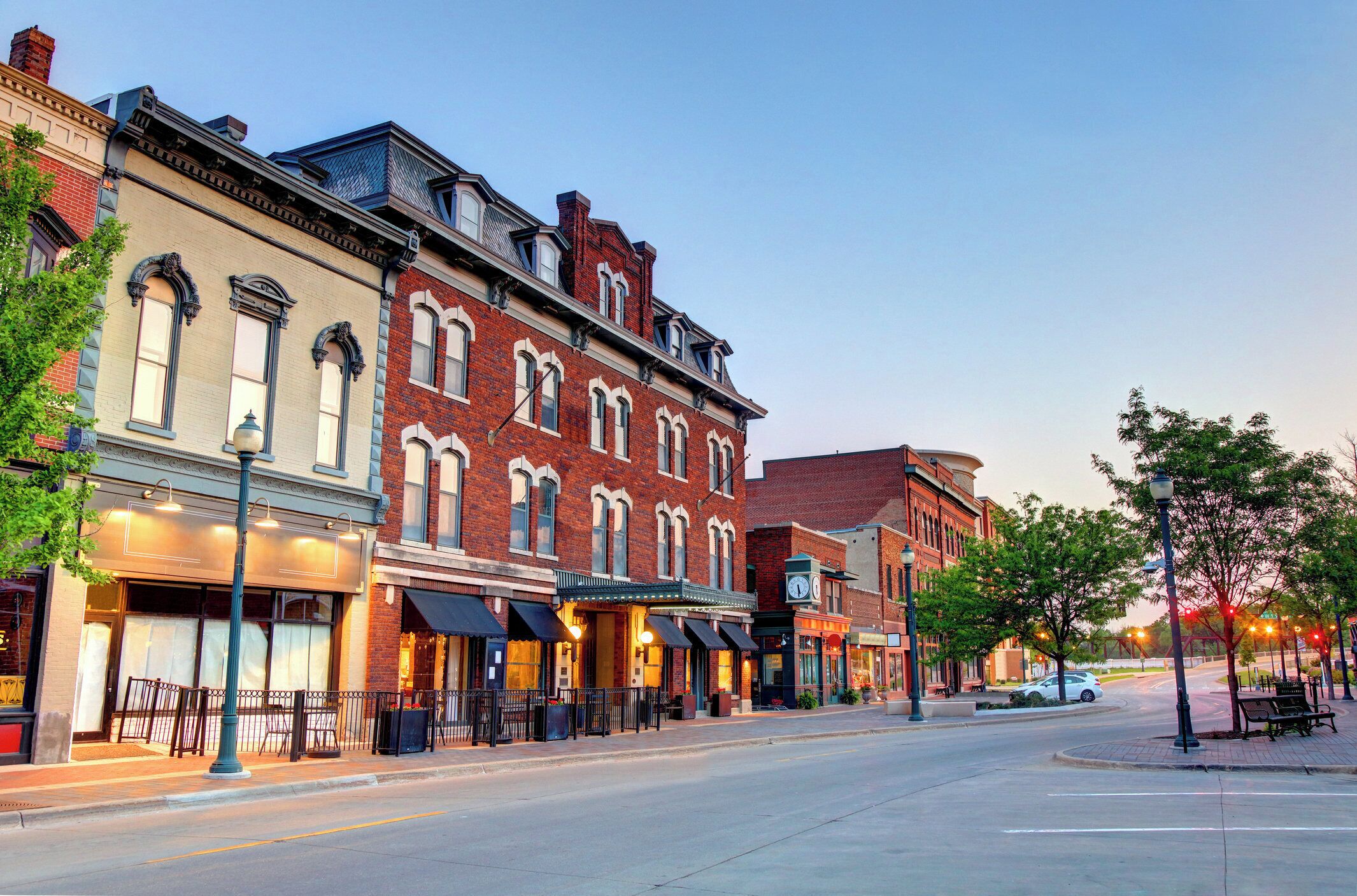 A street lined with historic buildings, some with storefronts and outdoor seating.