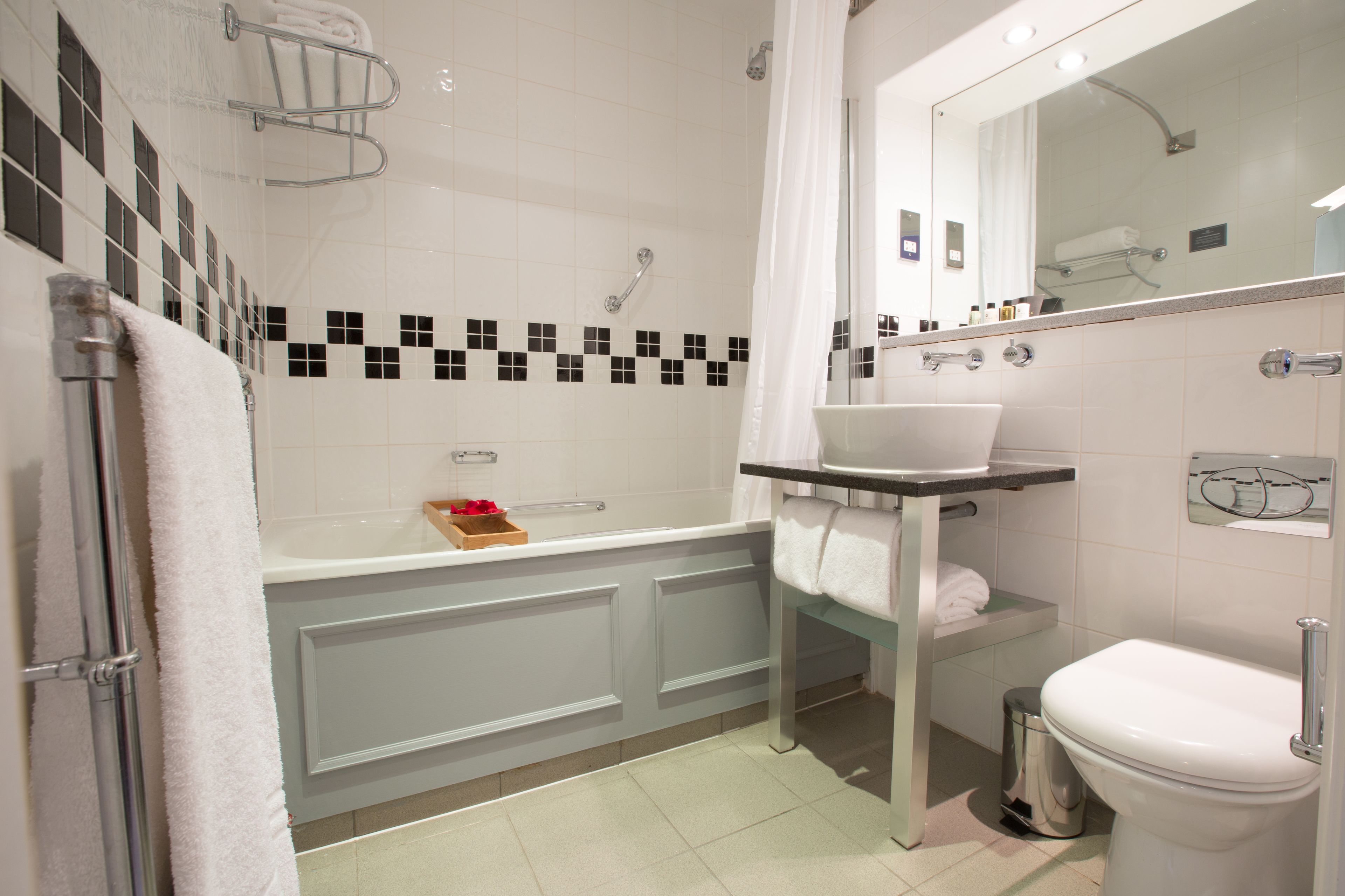 A modern bathroom with a bathtub, toilet, and sink.