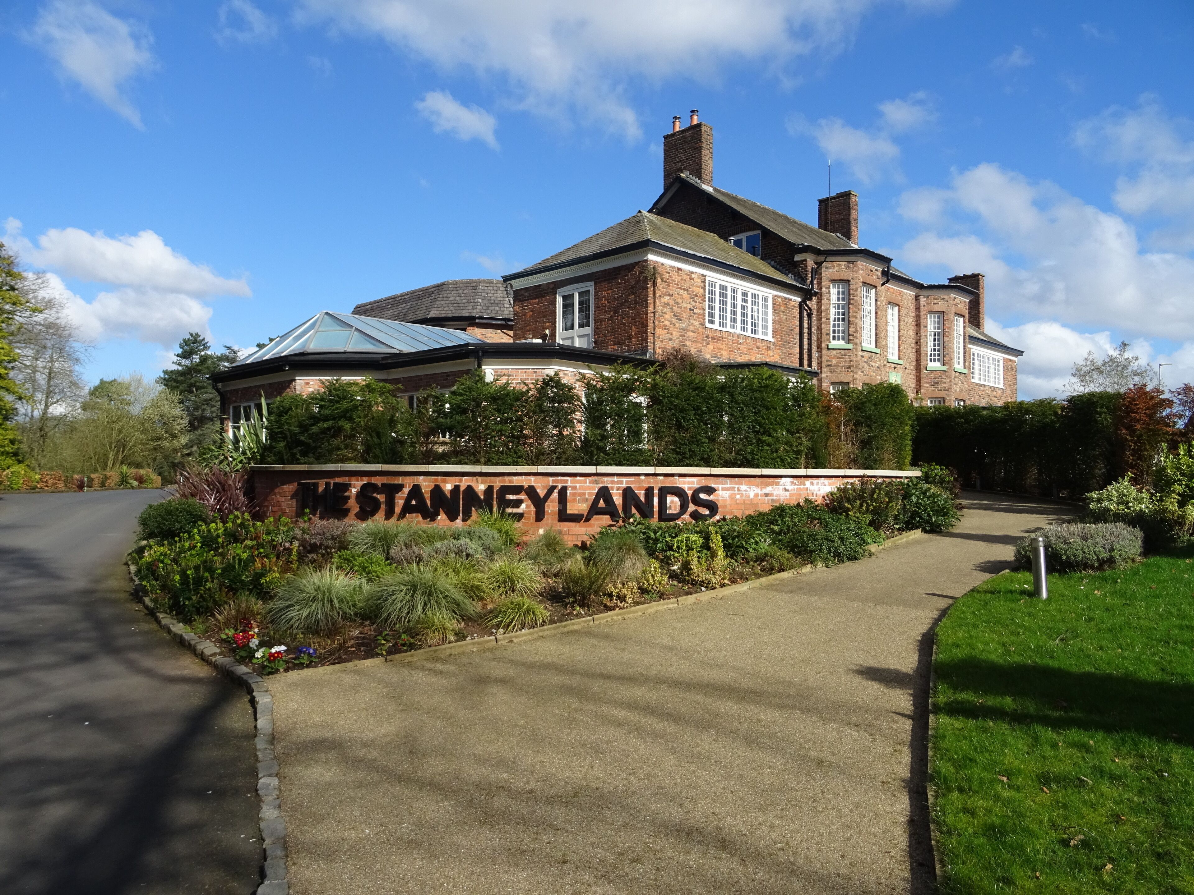 A large brick house with a sign reading "The Stanleys".