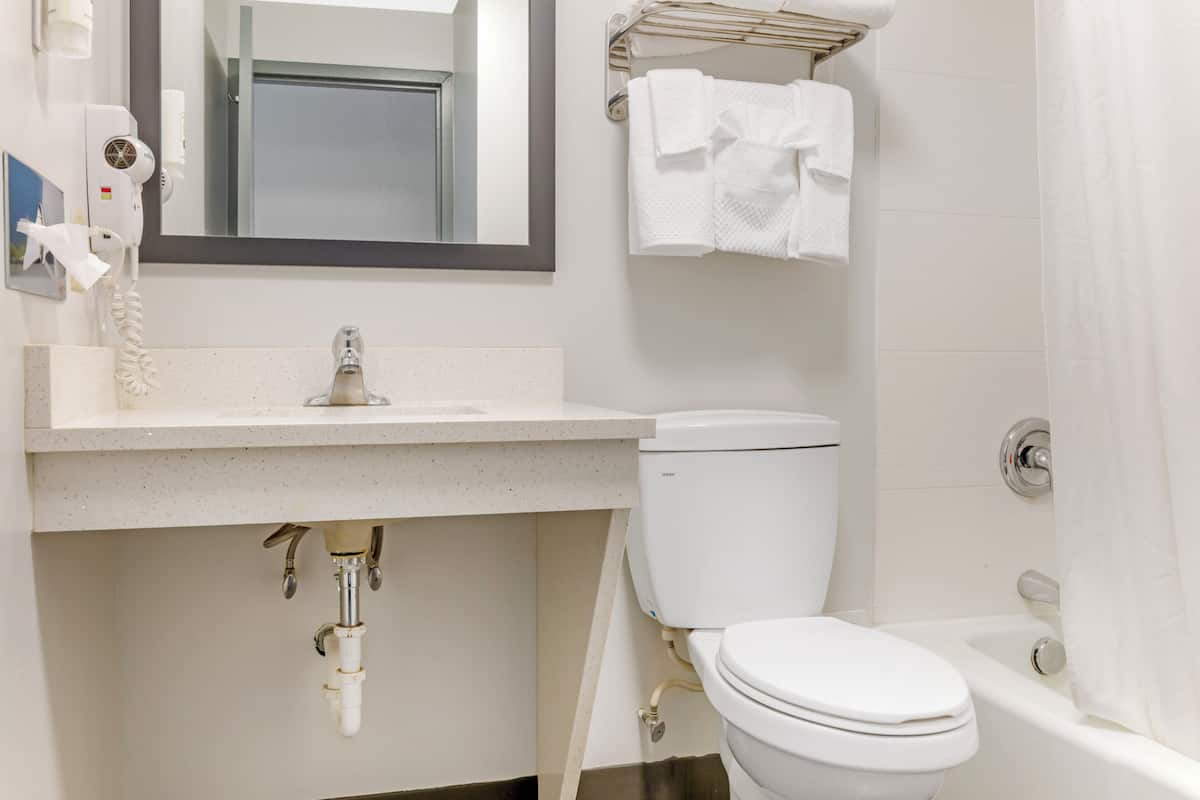A bathroom with a toilet, sink, and bathtub.