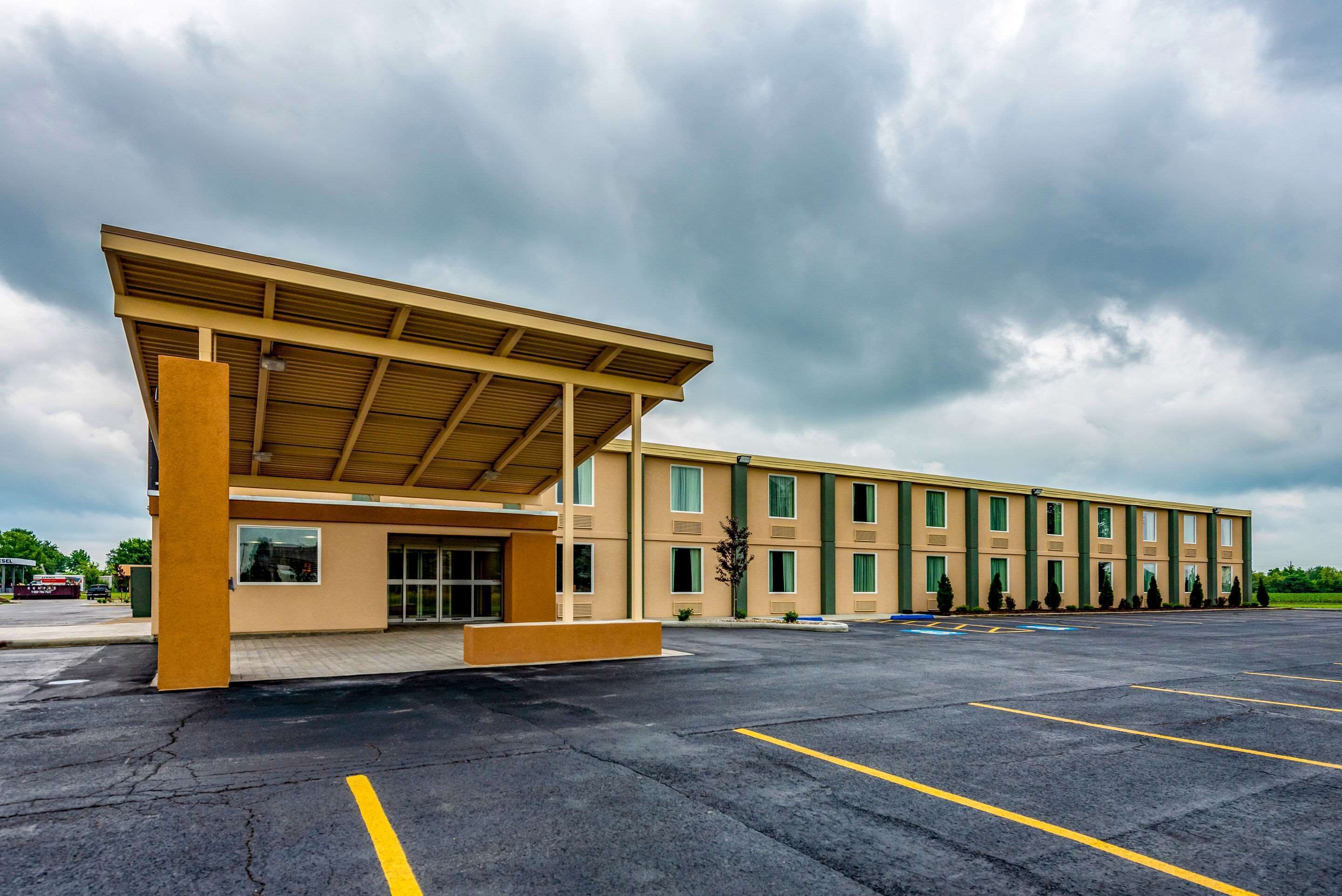 A multi-story hotel with a covered entrance and a parking lot.
