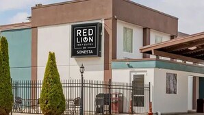 A Red Lion Inn & Suites building with a modern design, including a covered entrance and a parking area. - Red Lion Inn & Suites Bucyrus North (Bucyrus)