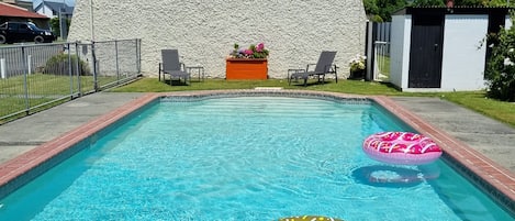 Una piscina al aire libre, sillones reclinables de piscina