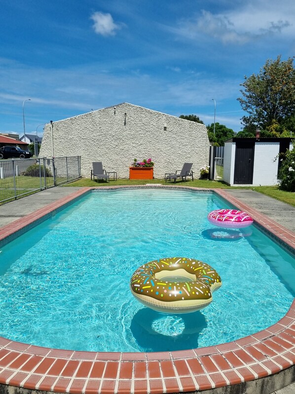 Una piscina al aire libre, tumbonas