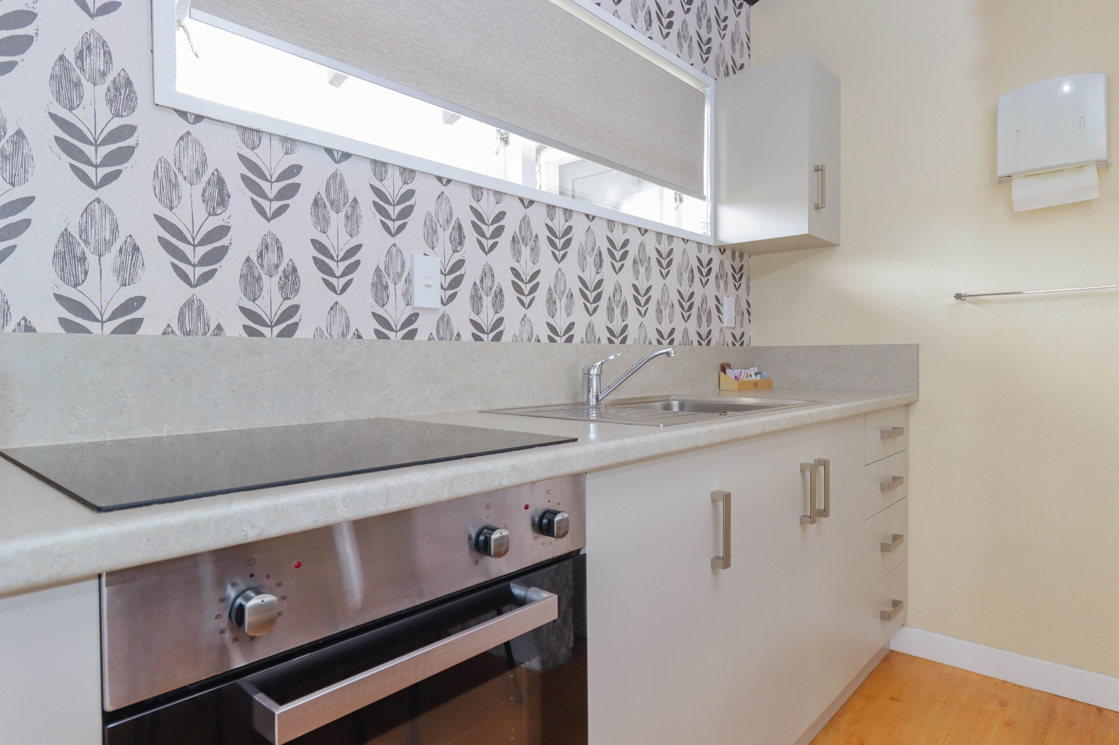 A kitchen with a built-in oven, a sink, and a microwave.