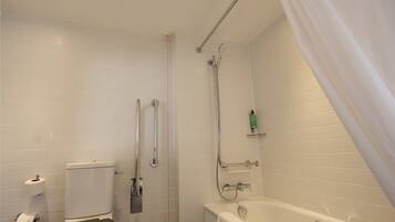 Een badkamer met toilet, douche en bad.