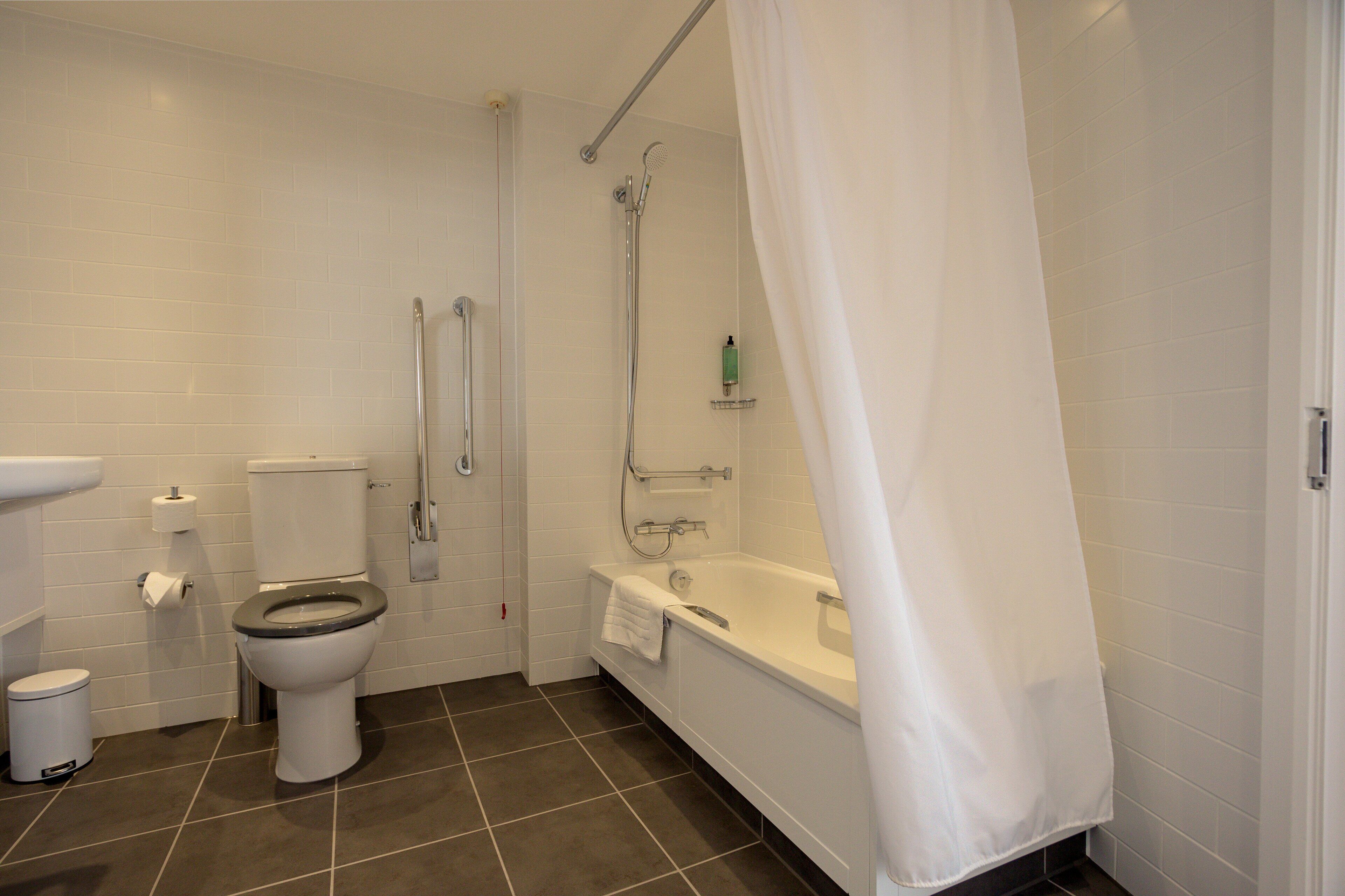 A bathroom with a toilet, bidet, and bathtub.