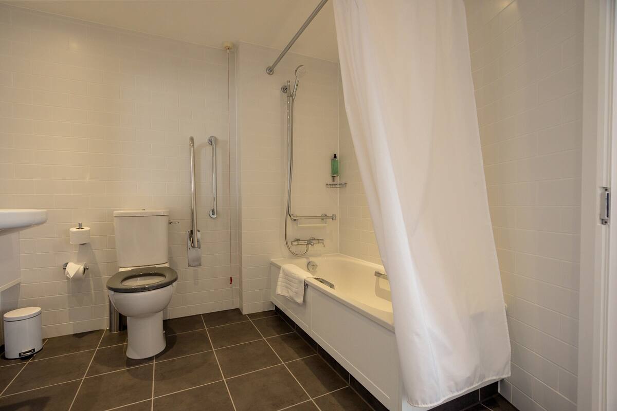 A bathroom with a toilet, bidet, and bathtub.