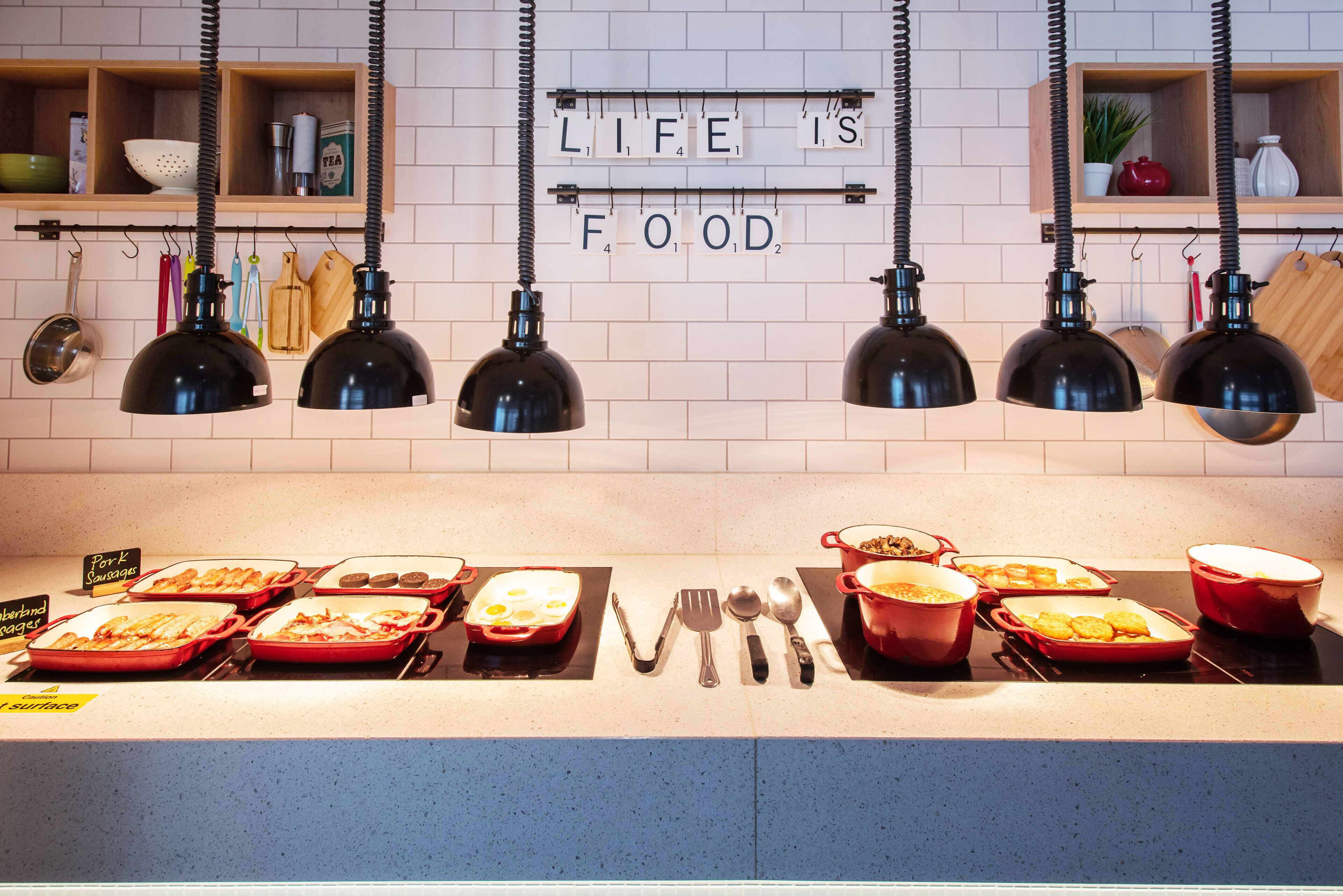 A buffet setup with various dishes and utensils.