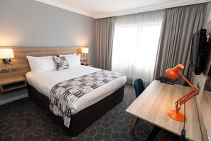 أغطية فراش متميزة وخزنة داخل الغرفة ومكتب وستائر تعتيم