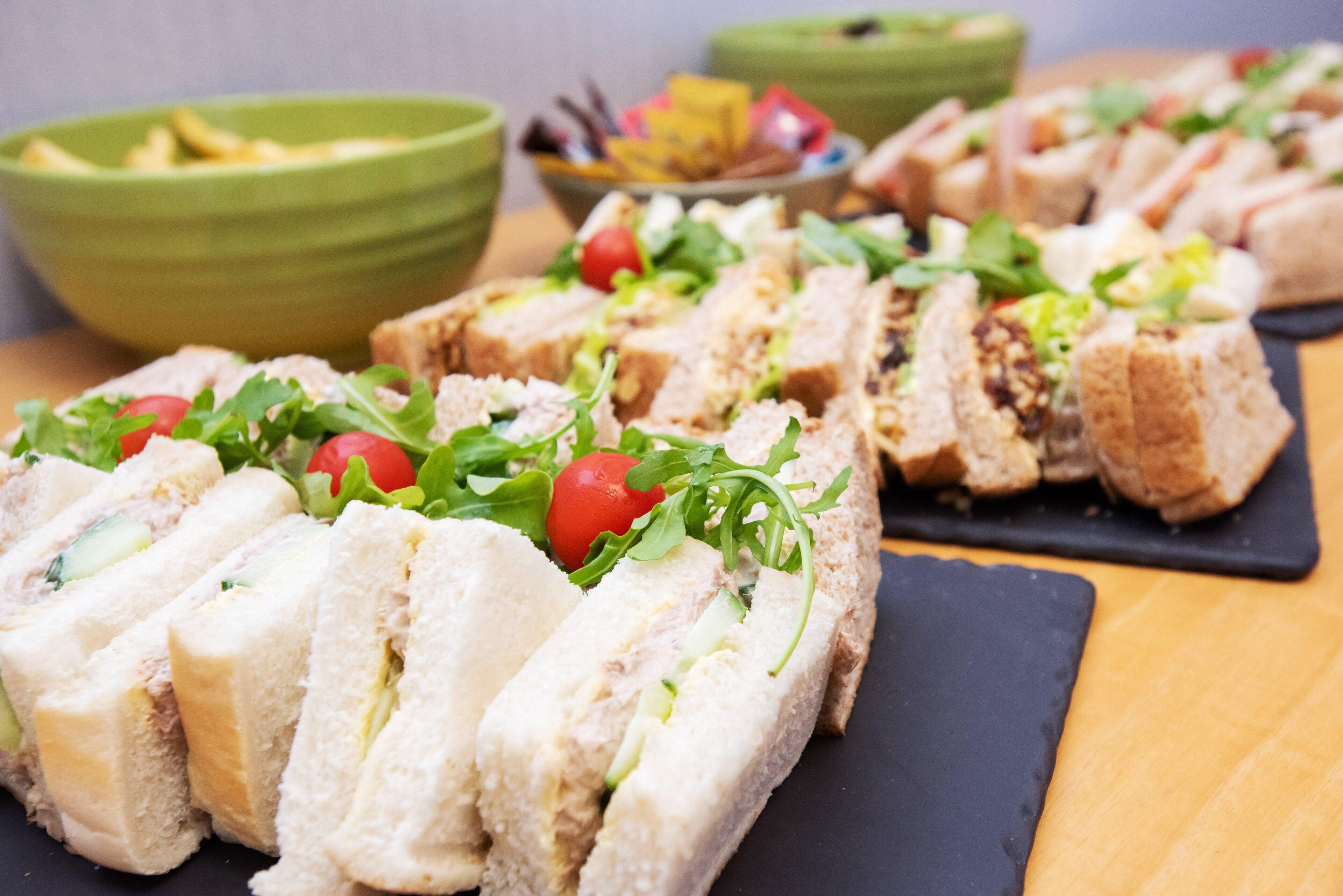 A variety of sandwiches and salads on a table.