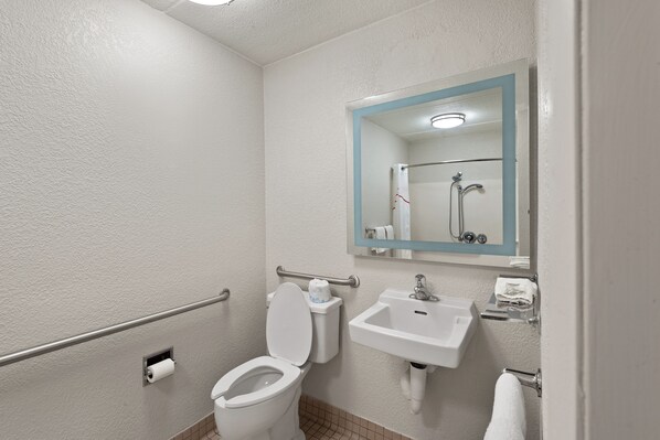 A bathroom with a toilet, sink, and shower.