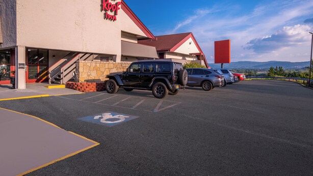 Een Red Roof Inn met een parkeerplaats, een Jeep en een zilvergrijze auto.