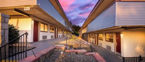 Une rangée de chambres de motel, avec un chemin de gravier menant à l’entrée.