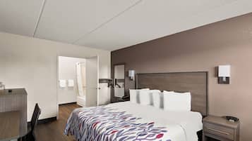 Ein Hotelzimmer mit Bett, Nachttisch und Schreibtisch mit Stuhl.