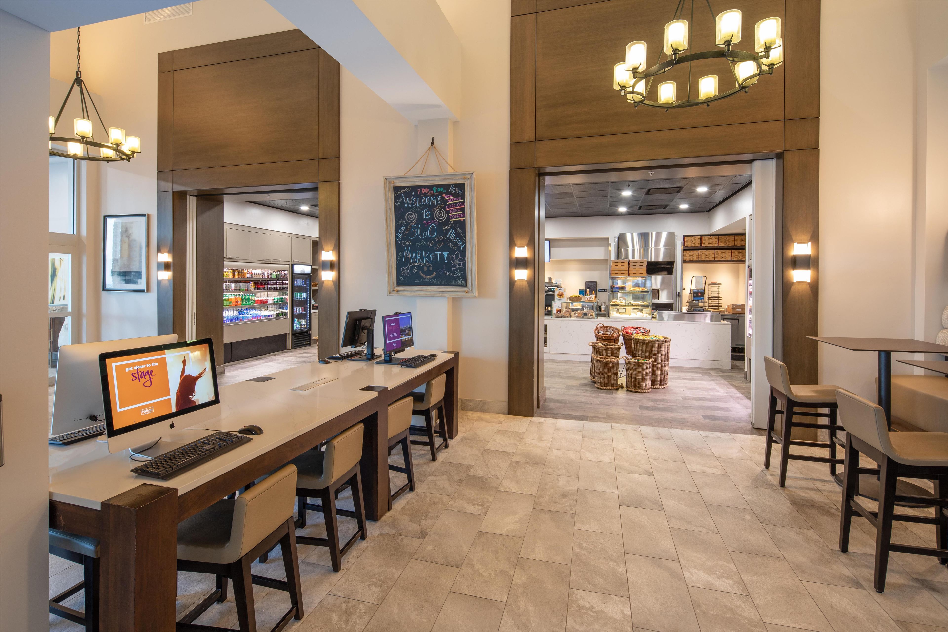 Un hall d’hôtel comprenant un comptoir d’accueil, un espace salon et une vue sur la cuisine.