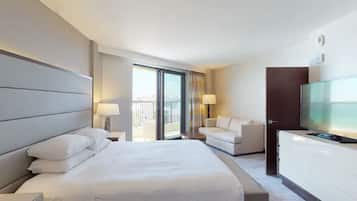 Une chambre d’hôtel moderne dotée d’un grand lit, d’une télévision, d’un canapé et d’un balcon avec vue.