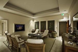 A hotel lobby with a seating area, artwork on the walls, and a bar with amenities.