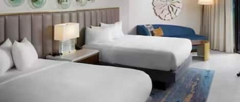 A hotel room with two beds, a nightstand with a lamp, a decorative wall piece, and a large window with curtains.