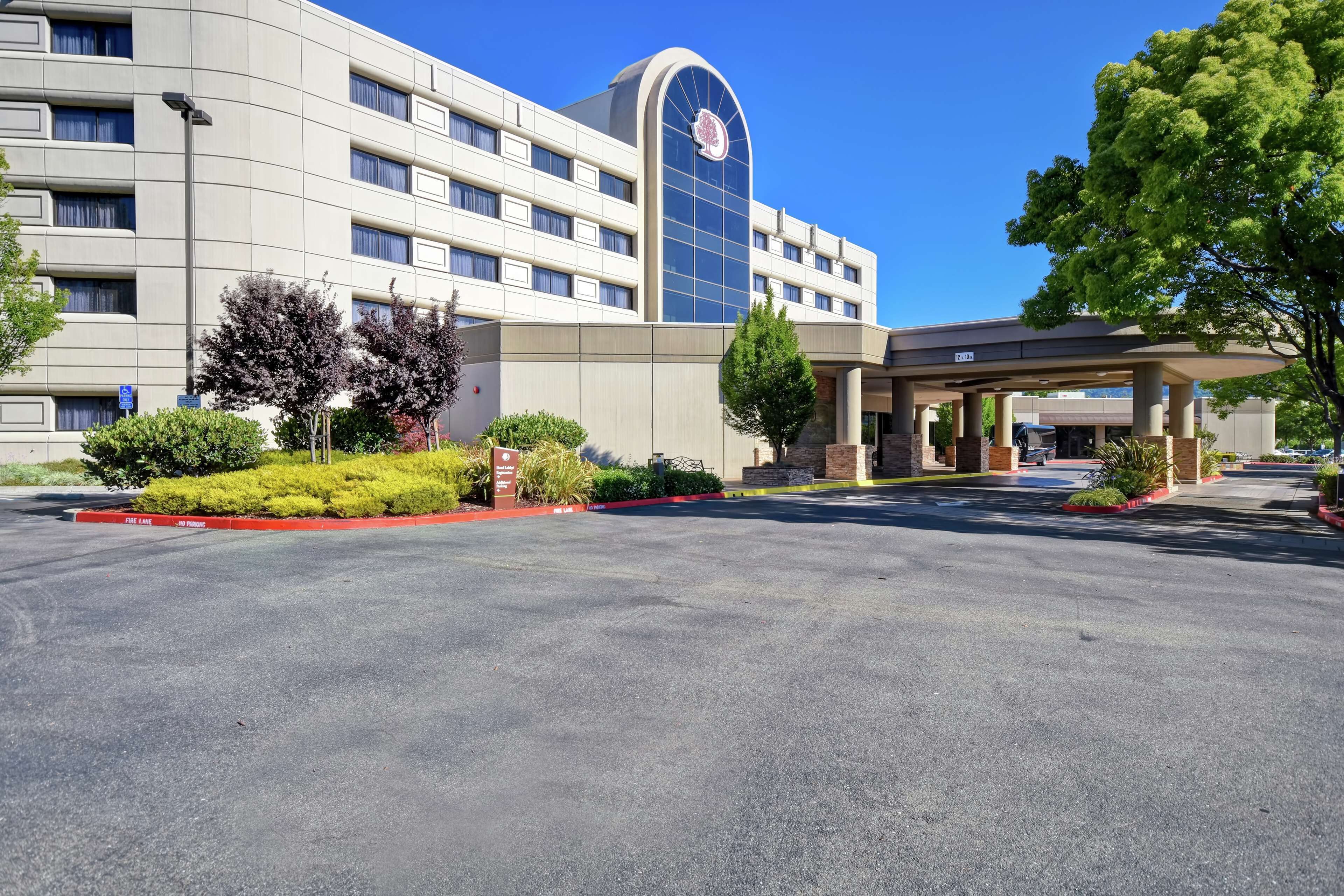 A hotel with a modern design, featuring a large glass facade and a curved entrance.
