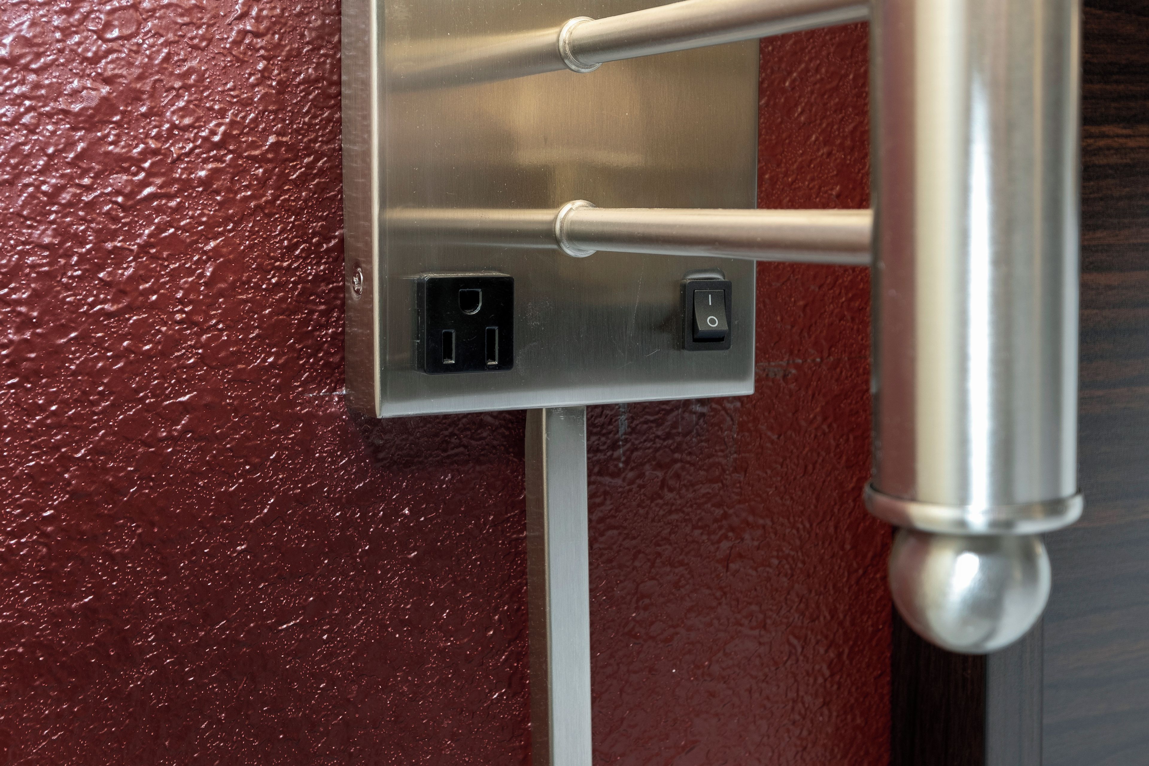 Un cuadro eléctrico metálico con dos interruptores y un cable conectado.