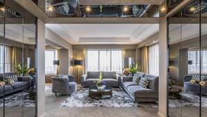 Un salon moderne comprenant un canapé, une table basse et un grand miroir.